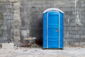 Baustellentoilette vor einer Wand