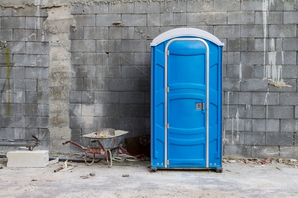 Baustellentoilette vor einer Wand
