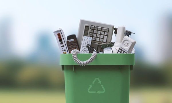 Recyclingtonne mit elektronischen Kleingeräten gefüllt