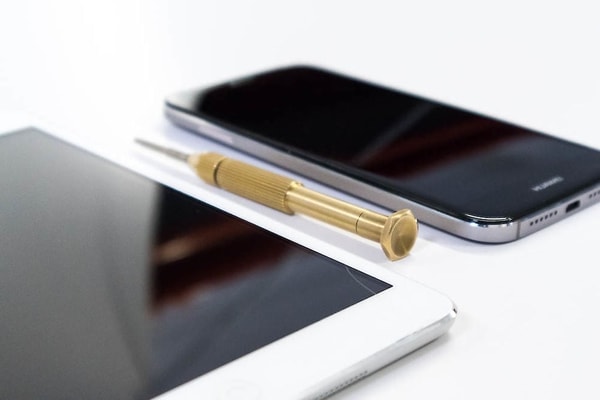 Tablet und Smartphone liegen nebeneinander auf einem weißen Tisch